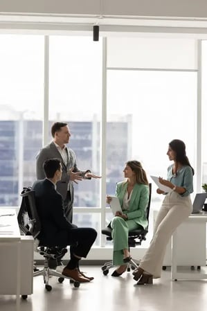 positive-business-team-meeting-brainstorming-training-talking-urban-office-space-focus-group-leader-holding-briefing-372984449